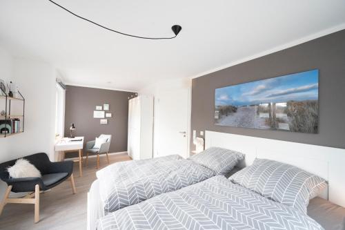 1 dormitorio con 1 cama, 1 silla y 1 mesa en Willem und Konsorten - Ankerbucht en Heiligenhafen