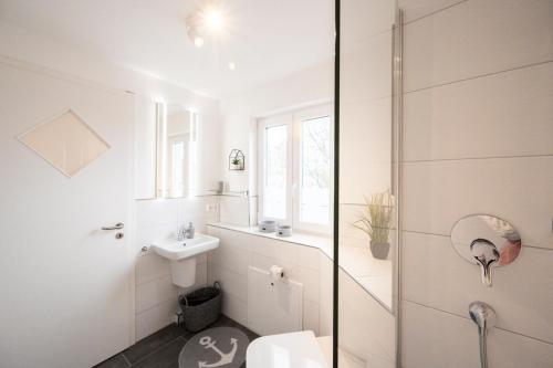 a bathroom with a shower and a toilet and a sink at Willem und Konsorten - Ankerbucht in Heiligenhafen