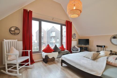 ein Schlafzimmer mit einem Bett und einem großen Fenster in der Unterkunft Traumhaus Heiligenhafen in Heiligenhafen