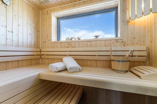 a sauna with two towels and a window at Traumhaus Heiligenhafen in Heiligenhafen