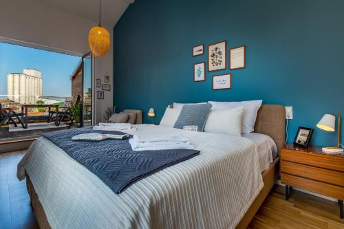 a bedroom with a large bed with a blue wall at Willem Waterkant in Heiligenhafen