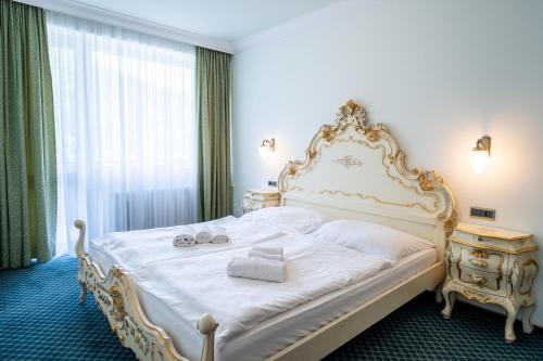 a bedroom with a large white bed with towels on it at Kúpele Brusno - LD Poľana in Brusno