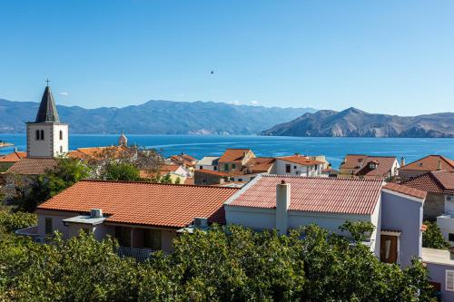 a view of a town with a church and the water at Apartments Crnekovic Tomislava 8 in Baška