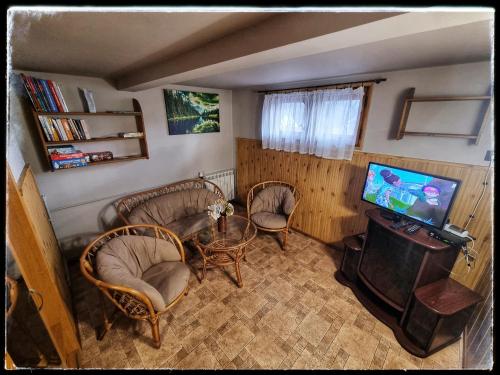 a living room with chairs and a table and a television at Noclegi u Marka in Czernichów