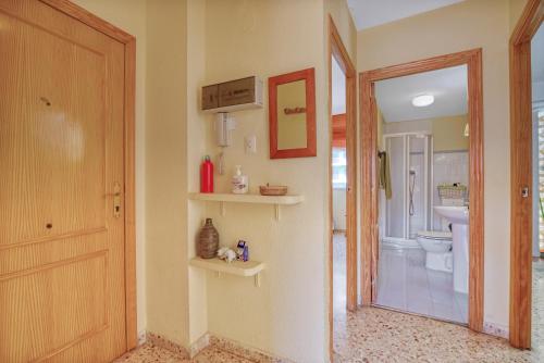 uma casa de banho com um WC, um espelho e uma porta em Eurosol em Gandia