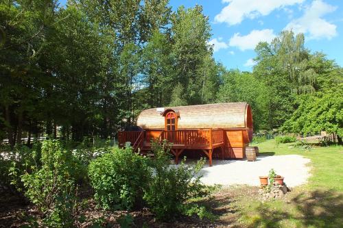 a large wooden cabin in a yard with trees at roulotte viticole in Xertigny