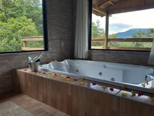 a large bath tub in a bathroom with windows at Portal da alvorada in Praia Grande