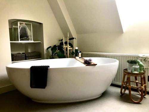 a large white bath tub sitting in a bathroom at Rijksmonument het Telmerck Zutphen in Zutphen