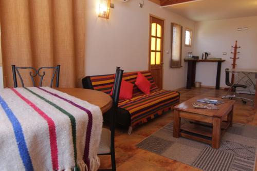 Habitación con cama, sofá y mesa. en Hotel El Bramador, en Copiapó