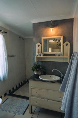a bathroom with a sink and a mirror at Blue Bell Guesthouse in Tzaneen
