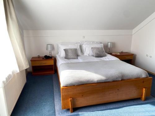 um quarto com uma cama grande e 2 mesas de cabeceira em Fado Apartments Lendava em Lendava