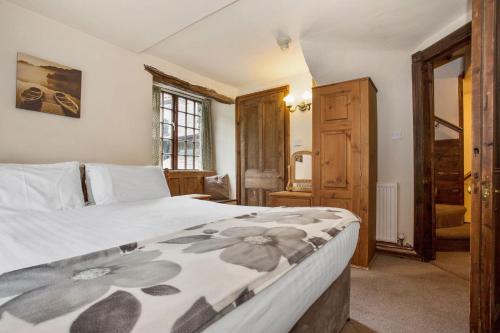 a bedroom with a bed with a floweridered blanket at The Mountain Cottages - Pelton Wheel in Coniston
