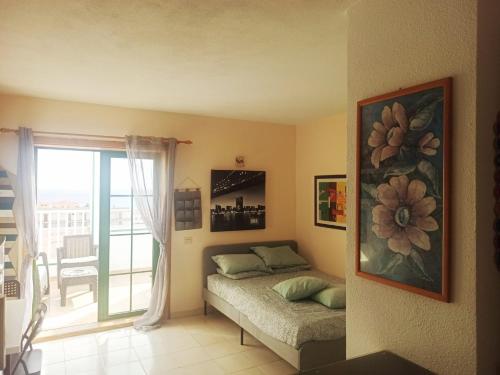 um quarto com uma cama e uma varanda em Caleta Paraiso 127 em Costa de Antigua