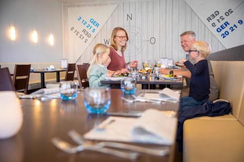 a family sitting at a table in a restaurant at TUI BLUE Sylt in Rantum