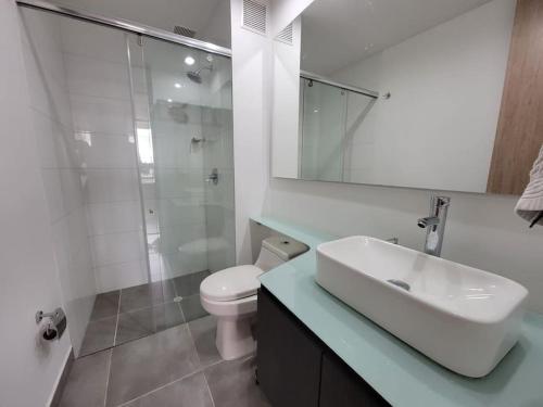 y baño con lavabo, aseo y ducha. en Luxurious apartment in Cedritos, Bogota, en Bogotá