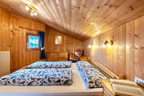 um quarto com 2 camas num chalé de madeira em Appartamento Confolia 1 em La Valle