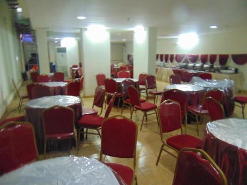 a dining room with red chairs and tables and tablesktop at فندق الواحة الماسية نجمة 1 in Makkah