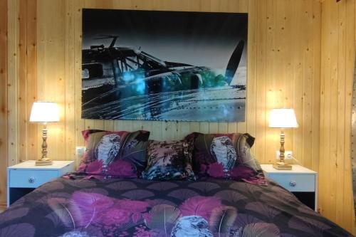 una camera da letto con un letto con due lampade e una foto a parete di Cottage romantique, son jacuzzi privatif, piscine a Rillieux-la-Pape