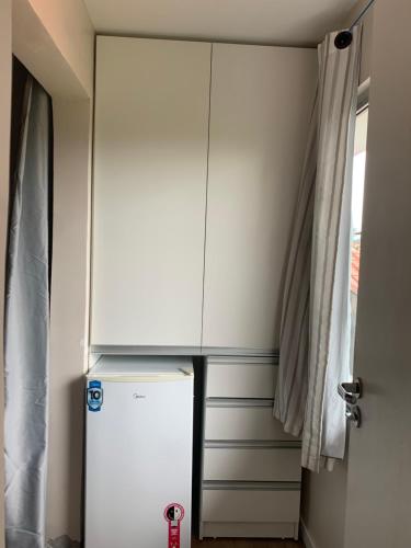 a white cabinet next to a refrigerator in a room at Recanto da Sol in Florianópolis