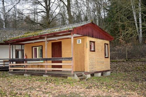 a small wooden house with a red roof at Areál Ontario Kyselka in Kysibl Kyselka