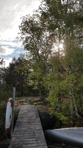 a wooden boardwalk leading to a river with trees at Tofvehults Boende in Skaftet