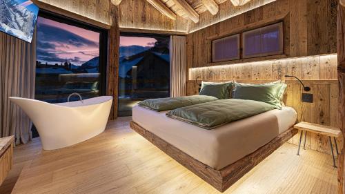 um quarto com uma cama e uma grande janela em Akchalet Akon em Livigno