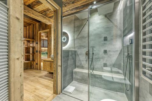 La salle de bains est pourvue d'une cabine de douche en verre. dans l'établissement Akchalet Akon, à Livigno