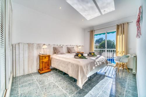 um quarto branco com uma cama e uma varanda em Ideal Property Mallorca - Casa Osborne em Port d'Alcudia