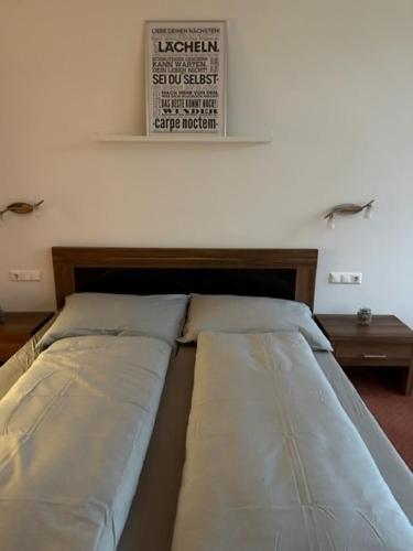 a bed in a room with a sign on the wall at Pension COLUMBIA inkl. Frühstück im Zentraum in Bad Gleichenberg