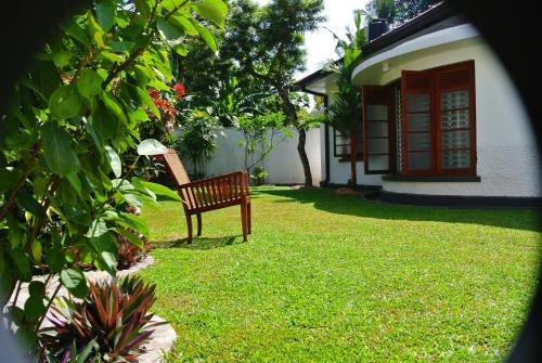 a bench sitting in the yard of a house at "27" Spathodea- Oasis in the City in Colombo