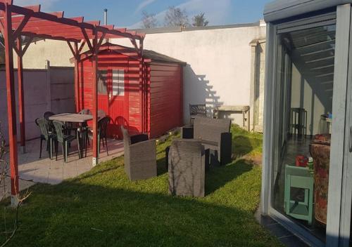 a backyard with a table and a red shed at Gîte Les Galipes in Mareuil-sur-Ay
