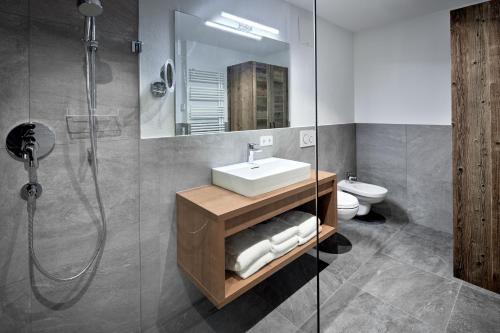 a bathroom with a sink and a shower at Alpin Residenzen Buchensteinwand St. Ulrich by Alpina-Holiday in Sankt Ulrich am Pillersee