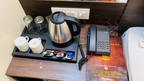 een bureau met een telefoon en een waterkoker bij Hotel Classic Inn Jaipur in Jaipur