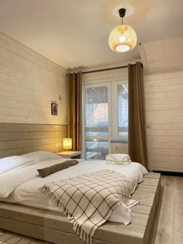 a bedroom with a large bed and a window at Sandal in Shaian