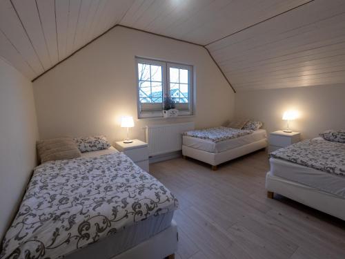 Schlafzimmer im Dachgeschoss mit 2 Betten und 2 Fenstern in der Unterkunft Holiday Bay in Władysławowo