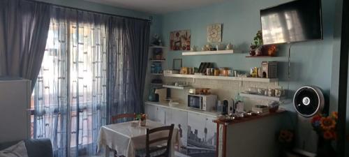 a living room with a table and a window with a microwave at B&B Il Girasole in Assemini