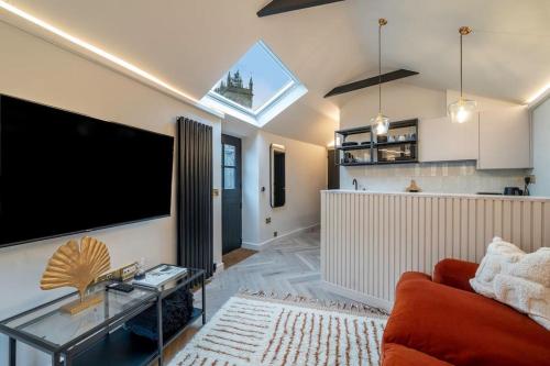 a living room with a large flat screen tv on a wall at Chic Cotswold Tiny Home - Oddity House in Blockley