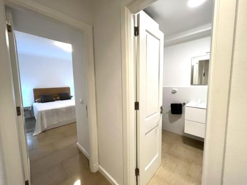 - une chambre avec un lit et une porte menant à une salle de bains dans l'établissement Apartamento Mar en Calma, à Las Palmas de Gran Canaria