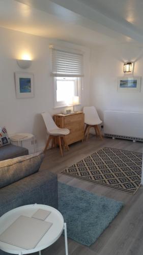 a living room with a couch and a table at The Picture House Stylish Apartment in Fowey in Fowey
