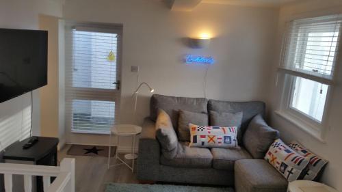 a living room with a couch and a television at The Picture House Stylish Apartment in Fowey in Fowey