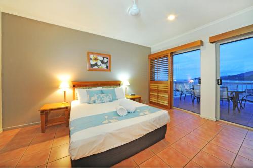 a bedroom with a bed with a view of the ocean at at Boathaven Bay Holiday Apartments in Airlie Beach