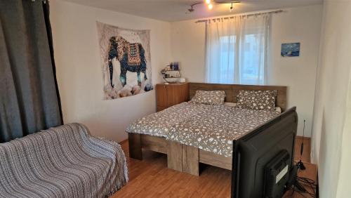 Schlafzimmer mit einem Bett und einem Flachbild-TV in der Unterkunft Simple 3-room apartment in Kukuljanovo