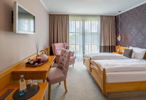- une chambre d'hôtel avec un lit et un bureau dans l'établissement Krone am Park - Gästehaus des Hotel Krone, à Alzenau