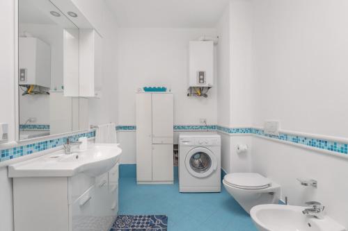 a white bathroom with a washing machine in it at Villetta Cala Rossa in Terrasini