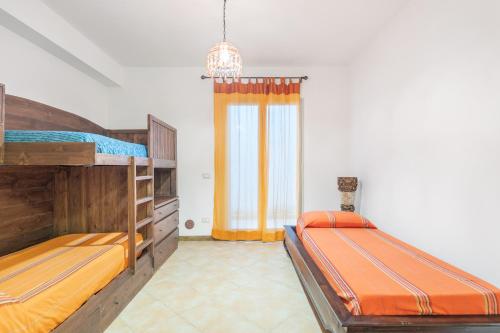 a bedroom with two bunk beds and a window at Villetta Cala Rossa in Terrasini
