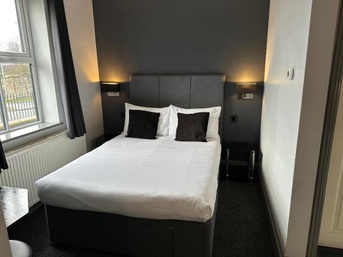 a bedroom with a large bed with white sheets and pillows at The Castle in Norwich