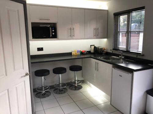 a kitchen with white cabinets and black counter tops at The Castle in Norwich