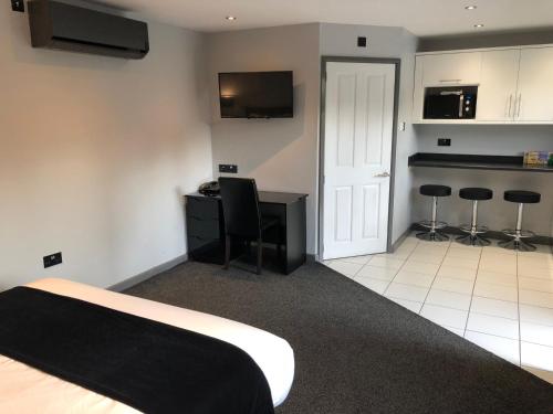 a bedroom with a bed and a desk and a kitchen at The Castle in Norwich