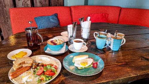 a wooden table with plates of breakfast foods and coffee at New Gudauri Lofts by Gudauri Travel in Gudauri