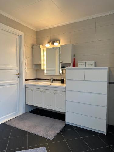una cocina con armarios blancos y fregadero en Familievennlig leiligheten leies ut på Sørlandet. en Vennesla